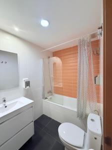 a bathroom with a toilet and a sink and a shower at Iberflat Apartamentos Marina Suites in Grao de Castellón +65 photos