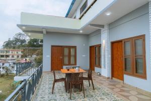 a house with a balcony with a table and chairs at Baatuli Homestay in Nainital