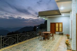 a balcony of a house with a table and chairs at Baatuli Homestay in Nainital