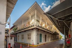 a white building with a balcony on a street at Casa AcoModo at Casco Viejo 6BR Mansion w Pool in Panama City