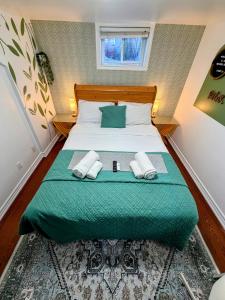a bedroom with a bed with a green comforter at Private room near subway & shops in Toronto