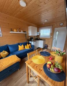 a living room with a table and a blue couch at Słoneczna Gąska in Gąski