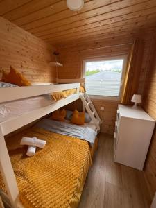 a bedroom with two bunk beds and a window at Słoneczna Gąska in Gąski