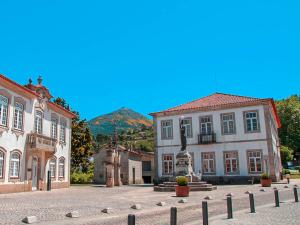 a building with a statue in the middle of a courtyard at Casa do Rodrigo in Mondim de Basto