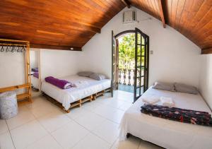two beds in a room with a wooden ceiling at Nova Perola de Guaruja in Guarujá