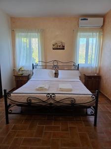 a large bed in a bedroom with two windows at Masseria La Rocca in Pacentro