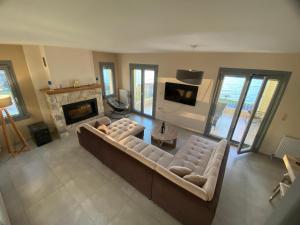 a living room with a couch and a fireplace at Athos view house in Agios Ioannis Kaspaka