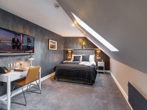a bedroom with a large bed and a desk and a desk at Hotel 30 Five in Aberdeen