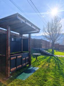 a picnic shelter with a table in the grass at Moon Lake Bicaz - Casa Oia in Buhalniţa +61 photos