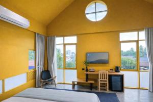 a bedroom with a bed and a desk with a tv at CenterPoint Thong Sala in Thong Sala