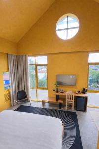 a bedroom with a bed and a desk and a tv at CenterPoint Thong Sala in Thong Sala