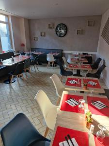 a restaurant with tables and chairs in a room at Relais du méne in Collinée