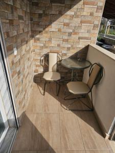 a patio with a table and chairs and a brick wall at Anemoni apartment Asprovalta in Asprovalta