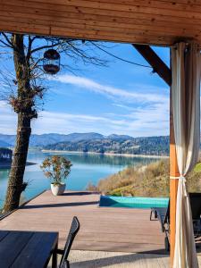 a wooden deck with a view of a lake at Moon Lake Bicaz - Casa Oia in Buhalniţa