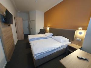 a hotel room with a bed and a table at Akdeniz Pension in Ludwigsfelde