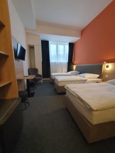 a hotel room with four beds and a television at Akdeniz Pension in Ludwigsfelde +42 photos