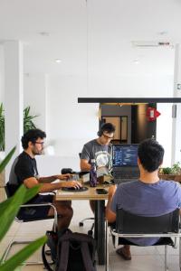 a group of men sitting at a table with a laptop at Las Golondrinas Mar del Plata in Mar del Plata +149 photos