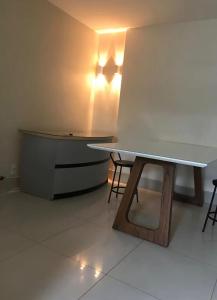a table in a room with chairs and a counter at Quarto Sol in Brasília