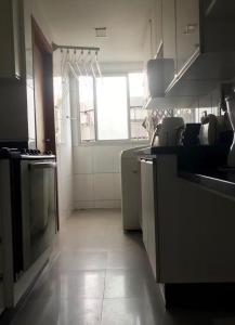 a kitchen with a sink and a stove at Quarto Sol in Brasília