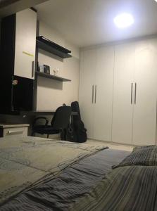 a bedroom with a bed and a desk and a chair at Quarto Sol in Brasília
