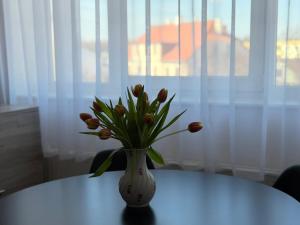a vase filled with flowers sitting on a table at Kesk Central Apartment in Valga