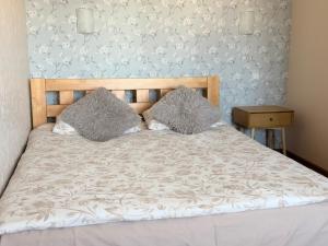 a bed with two pillows on it in a bedroom at Kesk Central Apartment in Valga