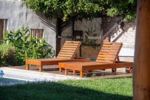 two wooden benches sitting next to a pool at Las Golondrinas Mar del Plata in Mar del Plata