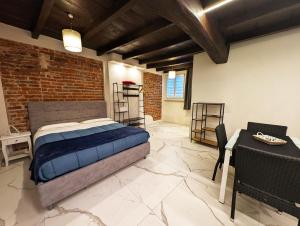 a bedroom with a bed and a brick wall at Le torri Virgo in Fossano