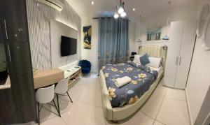 a bedroom with a bed and a desk and a television at Embassy Gardens Studio Accra in Accra