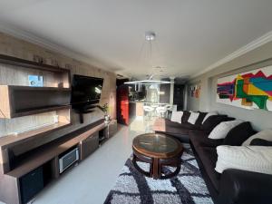 a living room with a couch and a tv at Apartamento Costa Azul Oasis frente CC La Vela in Porlamar
