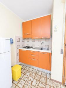 a kitchen with orange cabinets and a sink at Dimora Scacciapensieri a Marina di Cecina by Zoom In Earth in Marina di Cecina