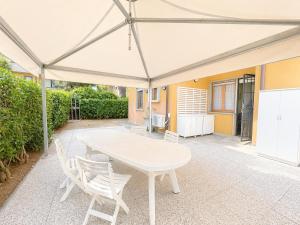 a white table and chairs under a white umbrella at Dimora Scacciapensieri a Marina di Cecina by Zoom In Earth in Marina di Cecina +16 photos