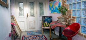 a room with a door and a chair and a table at At Home Hostel in Korçë