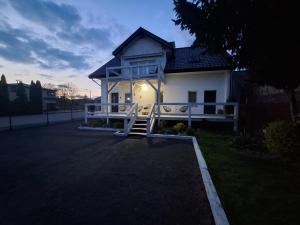 a white house with a gate in front of it at ApartamentyM&K in Balice
