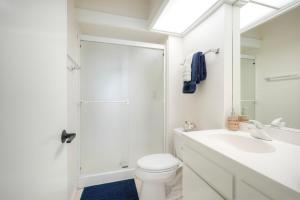 a white bathroom with a toilet and a sink at Oceanfront 2BR - Private Patio - Steps to Beach in Carlsbad +33 photos