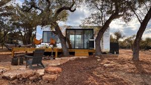 a tiny house sitting under a tree in a field at Lagom Retreat in Dripping Springs
