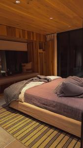 a large bed in a bedroom with wooden walls at Lagom Retreat in Dripping Springs