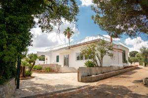 a white house with trees in front of it at Castellinaria Country Resort in Castellana Grotte