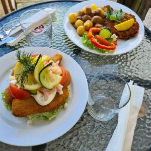 three plates of food on a glass table at Tostarps Pensionat in Hässleholm +32 photos