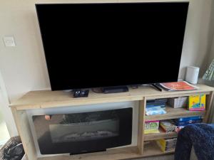 a flat screen tv sitting on a tv stand at Pines 15 in Porthcawl