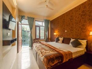 a bedroom with a large bed and a large window at Art-llers Homestay in Dharmsāla +8 photos