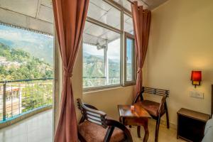 a room with a table and chairs and a window at Art-llers Homestay in Dharmsāla