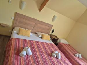 a bedroom with a bed with white shoes on it at Logis hôtel l'instant Mont le Viaur in Saint-André-de-Najac