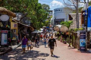 a group of people walking down a street at Magico s apartments in Playa del Carmen
