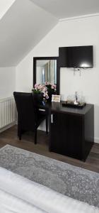 a black desk with a mirror and flowers on it at Vila CLASS in Vatra Dornei