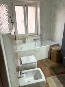 a white bathroom with a sink and a bath tub at Aurora sul mare in Terracina +14 photos