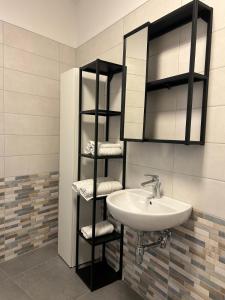 a bathroom with a sink and a shelf with towels at Relax Apartment in San Salvo +27 photos
