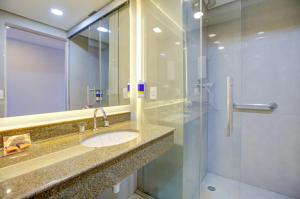 a bathroom with a sink and a shower at Comfort Ibirapuera in São Paulo