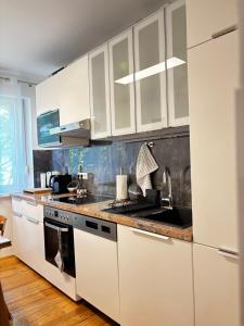 a kitchen with white cabinets and a stove top oven at Wien an Donau in Vienna