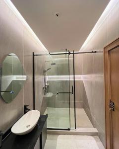 a bathroom with a glass shower and a sink at The Mansion in Abuja +44 photos